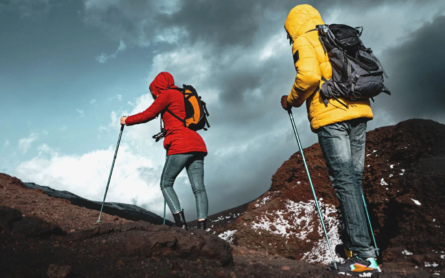 A group with hiking gear climbing up a volcano