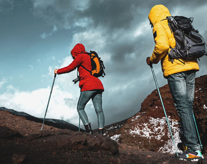 A group with hiking gear climbing up a volcano